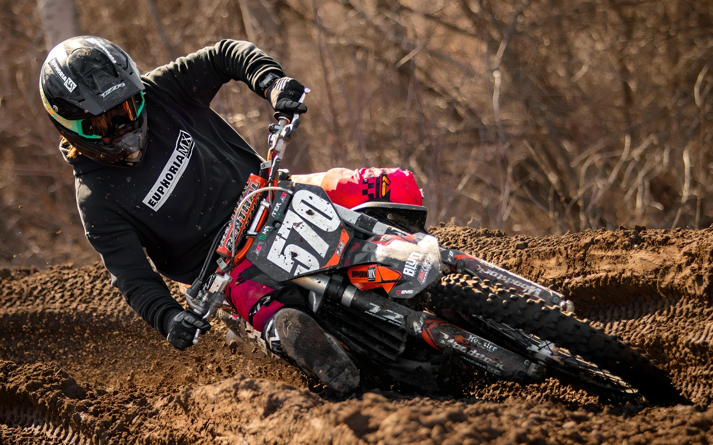 Motocross rider on dirt bike leaning hard into turn.