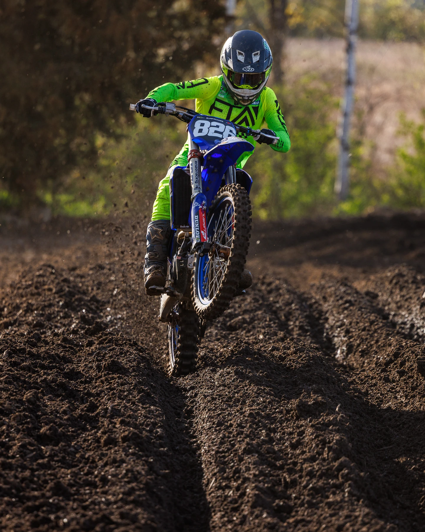 Motocross rider mid-jump on a dirt track.